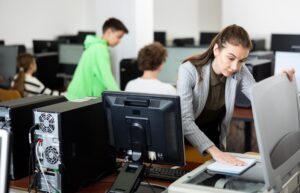 Interested young woman copying notes on copy machine in university library computer lab